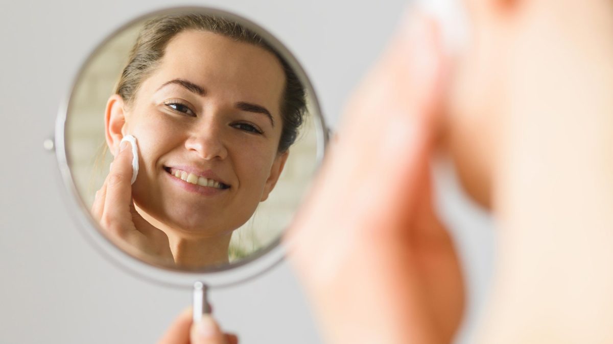 front-view-woman-cleaning-her-face-mirror